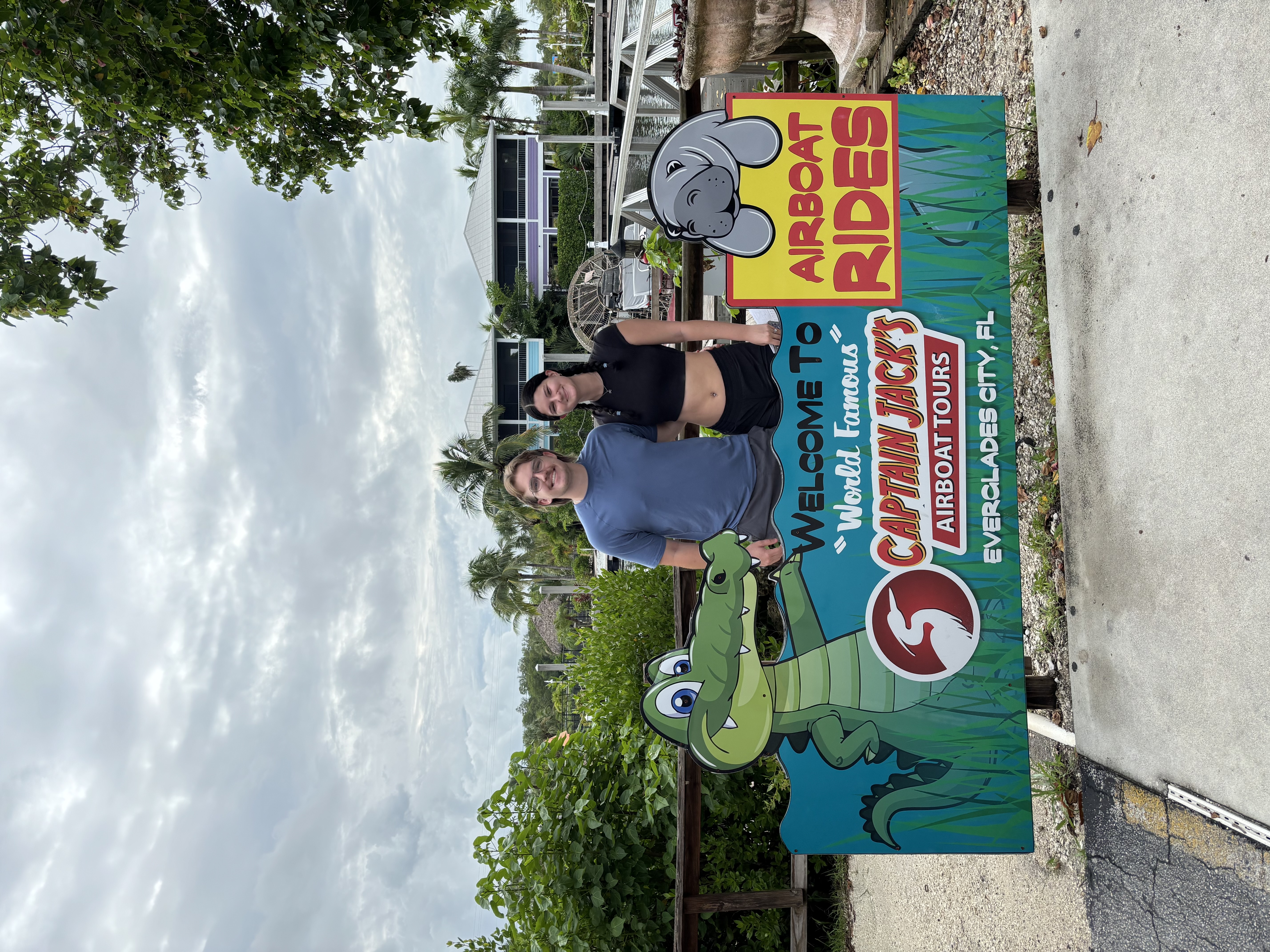 My wife and me beside the Captain Jack's Airboat Tours sign in Everglades City, Florida